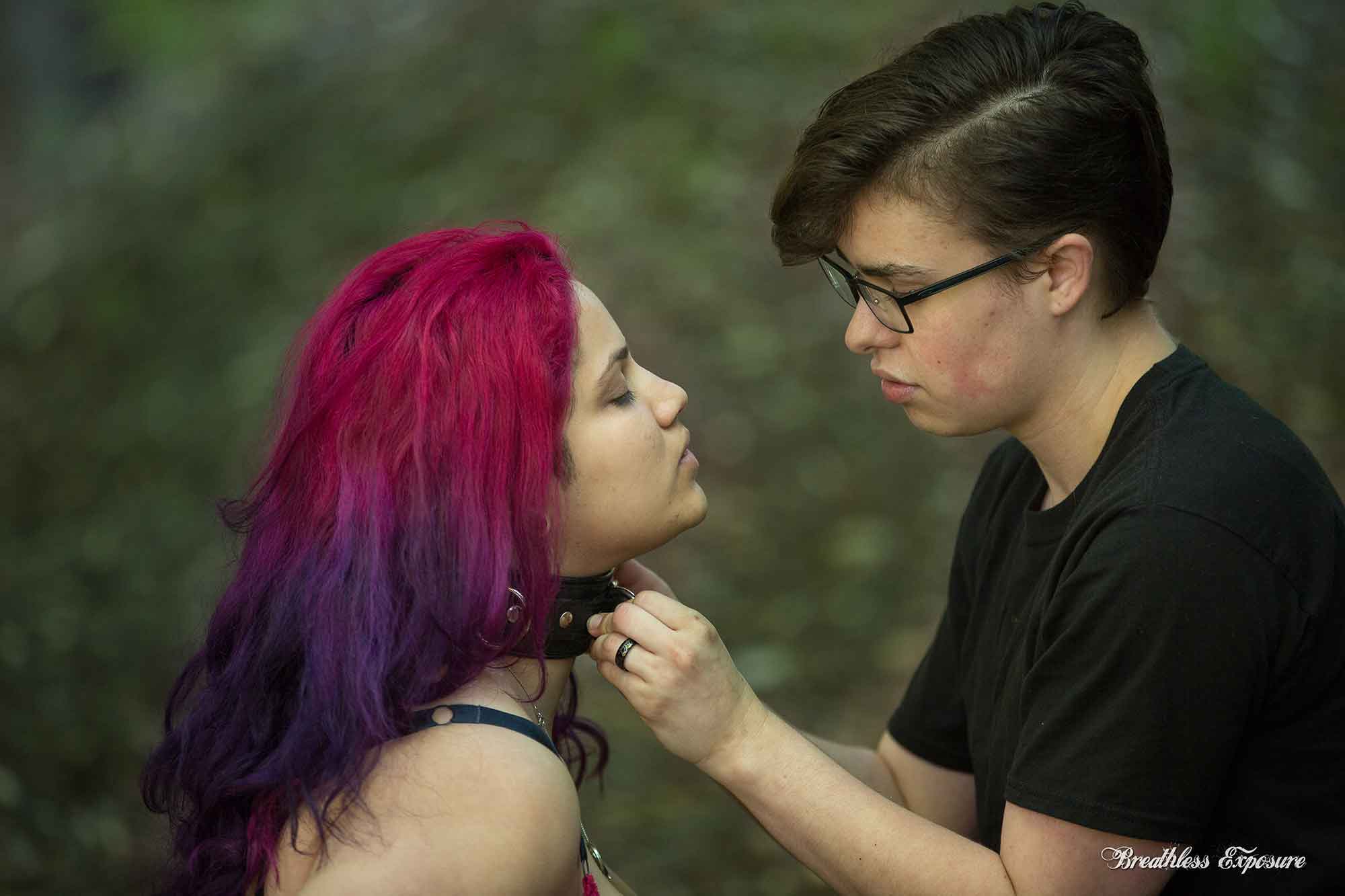 Boundless an individual collaring another individual with purple hair